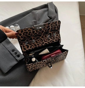 Détail du sac à bandoulière léopard montrant les compartiments internes et le loquet métal