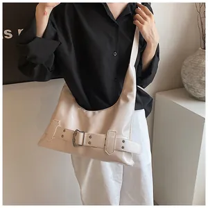 Chic beige crescent shoulder bag featuring wide buckle detail and premium glossy finish