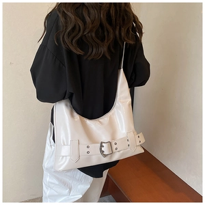 Detail of white glossy crescent shoulder bag featuring silver buckle and sleek texture