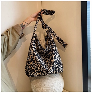 Detailed view of leopard print canvas tote bag with thick shoulder strap and knotted detail