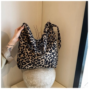 Close-up of stylish leopard print canvas tote bag with decorative knotted shoulder strap
