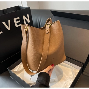 Détails du sac seau en cuir marron avec motif litchi et boucles métalliques dorées