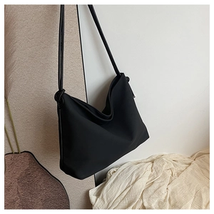 Grand sac cabas noir minimaliste en toile présenté dans un cadre de vie avec lumière naturelle