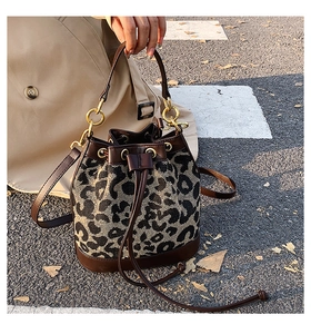 Close-up of leopard print bucket bag with drawstring closure and gold ring detail