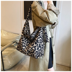 Leopard print canvas tote bag with large capacity and wide shoulder strap on model