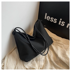 Vue détaillée du sac hobo noir avec doubles bretelles fines sur fond minimaliste