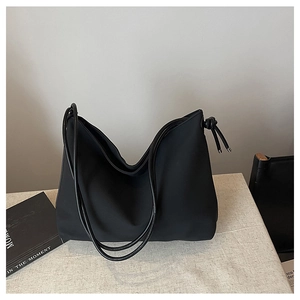Vue détaillée du sac cabas noir avec des accents de nœuds élégants et une texture lisse