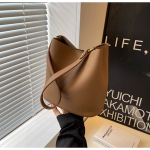 Détail de la texture en cuir grainé litchi de haute qualité de ce sac seau marron