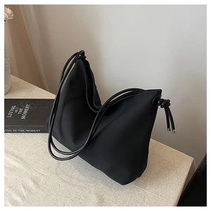 Détail du sac hobo noir minimaliste avec doubles bandoulières en corde et nœud décoratif