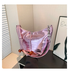 Detalle de bolso hobo rosa metálico con cadena plateada y cordón con cuentas de ámbar