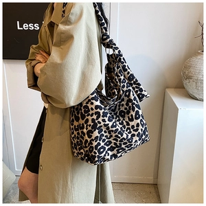 Detail of trendy leopard print canvas tote bag featuring large capacity and knotted strap