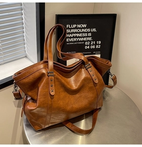 Close-up of brown vintage tote bag with star rivets and lychee texture leather detail