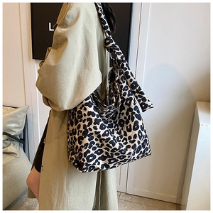 Detail of trendy leopard print canvas tote bag with wide knotted strap on model