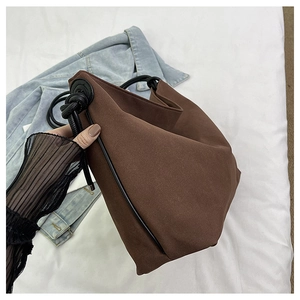 Détail d'un cabas en toile marron avec poignées en corde noire et style japonais épuré