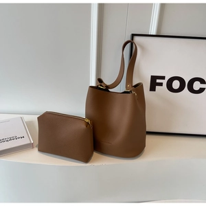 Détail du sac seau en cuir grainé caramel avec une petite pochette zippée assortie