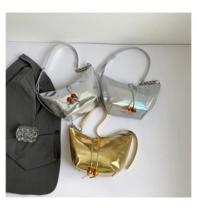 Detalle de bolsos de media luna metalizados con cadenas plateadas y cuentas de ámbar lujo