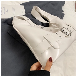 Close-up of white PU leather underarm bag with silver grommets and buckle details