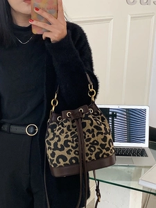 Fashionable leopard print bucket bag with leather drawstring and gold metal ring details