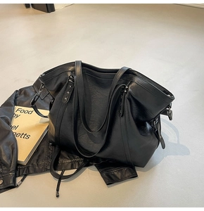 Detail of black large tote bag featuring star rivets and premium PU leather texture