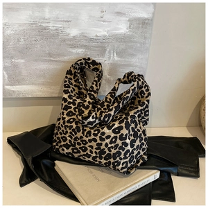 Close-up of leopard print knit tote bag on leather clothing in a stylish lifestyle setting