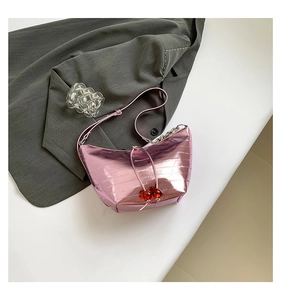 Detalle de bolso medialuna rosa metalizado con cuentas de cereza y cadena plata