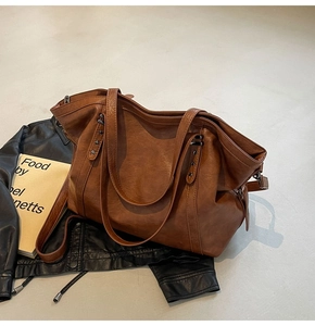 Detail of a large brown leather tote bag with star rivets and fine leather texture