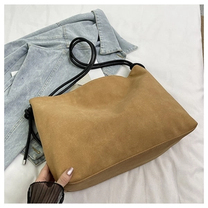 Détail du sac cabas en daim camel avec poignées en corde noire et fond large spacieux