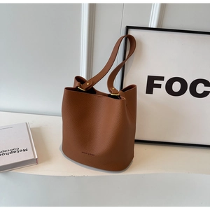 Détail du sac seau en cuir marron à motif litchi avec logo embossé et boucles dorées