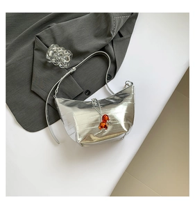 Detalle de bolso hobo plateado con cordón de cuentas de ámbar y cuero suave metalizado