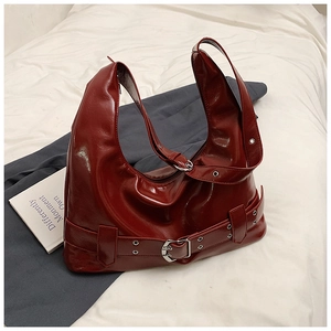 Detailed view of glossy burgundy leather hobo bag with silver buckle and vintage texture