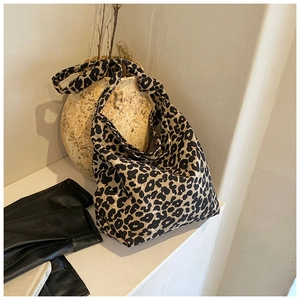 Soft canvas leopard print tote bag hanging on a ceramic vase in a minimal home setting