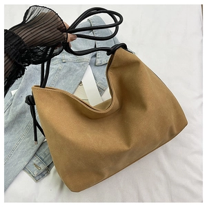 Détail du sac demi-lune en daim caramel avec bandoulière en cordon noir réglable