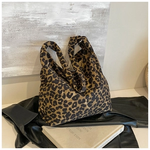 Detail shot of the trendy leopard print canvas tote bag on a black leather jacket background