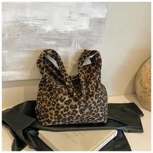Chic leopard print canvas tote bag with unique knotted handles on stylish display