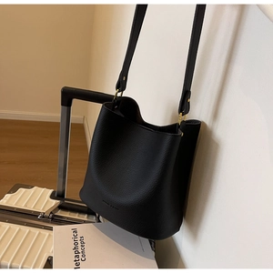 Détail du sac seau en cuir grainé noir avec anneau doré et bandoulière fine en cuir