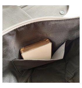 Primer plano del interior del bolso con forro negro y un práctico bolsillo interno