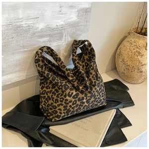 Detail of leopard print canvas tote bag with a slouchy silhouette on leather jacket