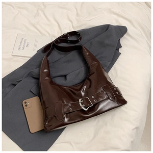 Detailed view of dark brown glossy leather hobo bag with silver buckle and belt accents