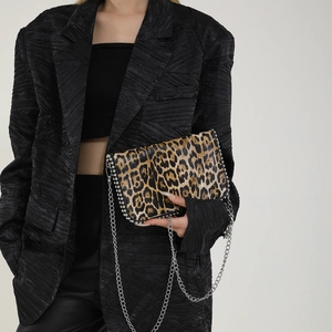 Close-up of leopard print chain bag featuring silver spherical stud trim and metallic details