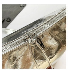 Detalle del bolso plateado metalizado con cremallera de metal premium y tirador de moda