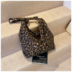 Detailed macro view of large leopard print canvas tote bag on stairs showing fabric texture