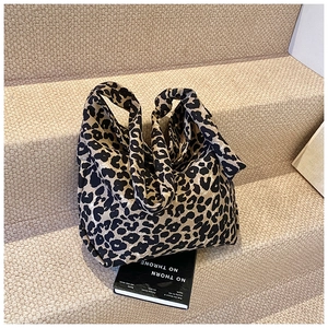 Close-up of leopard print canvas tote bag placed on a textured stone step for a stylish look