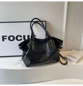 Close-up of black matte PU leather tote bag with magnetic pocket and silver buckles