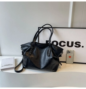 Detail of minimalist black tote bag with star rivets and premium leather texture