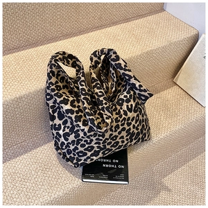 Close-up of leopard print canvas tote bag on a textured background for urban fashion style