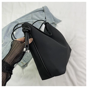 Détail du sac cabas noir minimaliste avec cordon à nœud et détails argentés