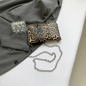 Detail of leopard print leather crossbody bag with silver chain strap and metal rivets
