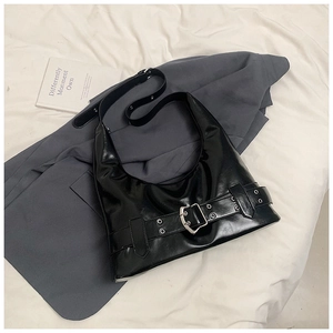 Detail of black leather underarm bag with silver buckle strap and metal eyelet accents