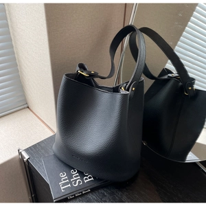 Détail du sac hobo en cuir grainé noir avec ferrures dorées et bandoulière réglable