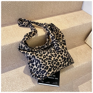 Detail of trendy leopard print canvas hobo bag with stylish knotted shoulder strap